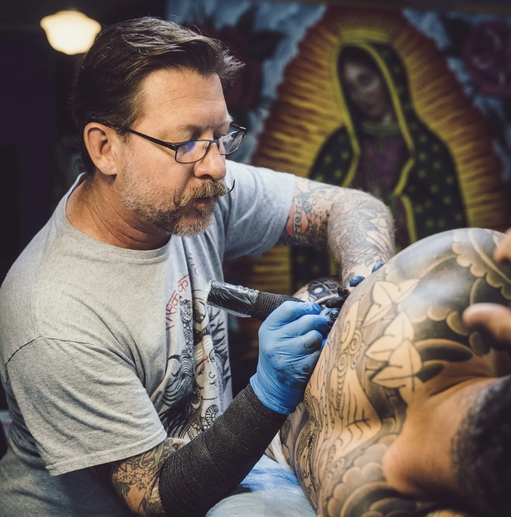 Kelly Edwards tattooing a large backpiece at Eternal Courage Tattoo